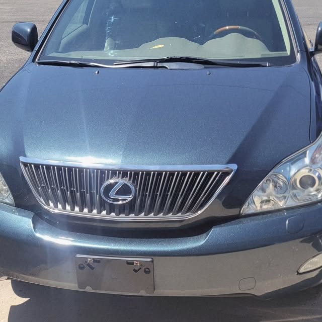 Close-up of a glossy, freshly detailed SUV hood and chrome grille showing a finished full detail